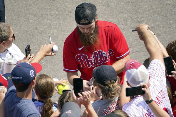Philadelphia Phillies outfielder Brandon Marsh signs autographs for fans as the team arrived at the Little League World Series Complex to watch the Smithfield, R.I. vs. Media, Pa. baseball game at the Little League World Series tournament in South Williamsport, Pa., Sunday, Aug. 20, 2023. (AP Photo/Tom E. Puskar)