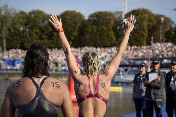 Gold medalist Sharon Van Rouwendaal, of the Netherlands, right, celebrates after crossing the finish line at the end of the marathon swimming women's 10km competition at the 2024 Summer Olympics, Thursday, Aug. 8, 2024, in Paris, France. (AP Photo/Vadim Ghirda)