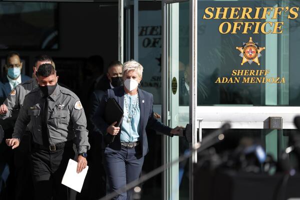 Santa Fe County Sheriff Adan Mendoza, left, and Santa Fe District Attorney Mary Carmack-Altwies exit the sheriff's office to address the media at a news conference in Santa Fe, N.M. Wednesday, Oct. 27, 2021. New Mexico authorities said Wednesday they have recovered a lead projectile believed to have been fired from the gun used in the fatal movie-set shooting. (AP Photo/Andres Leighton)