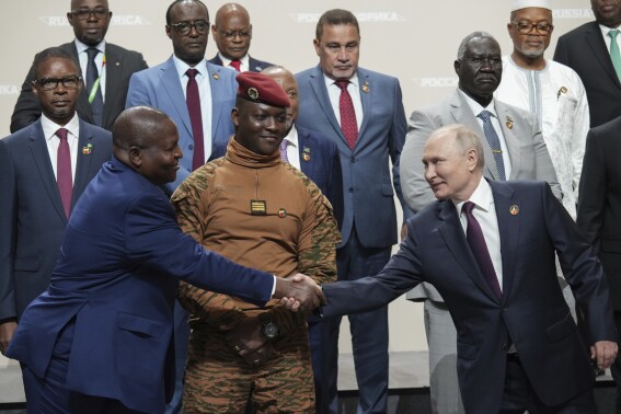 Russian President Vladimir Putin, right, and Mozambique President Filipe Nyusi shake hands during a family photo opportunity during the Russia Africa Summit in St. Petersburg, Russia, Friday, July 28, 2023. (Alexei Danichev, Sputnik, Kremlin Pool Photo via AP)