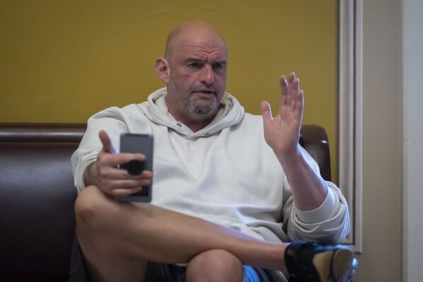Sen. John Fetterman, D-Pa., speaks to a reporter near the Senate chamber at the Capitol in Washington, March 14, 2025. (AP Photo/Ben Curtis, File)