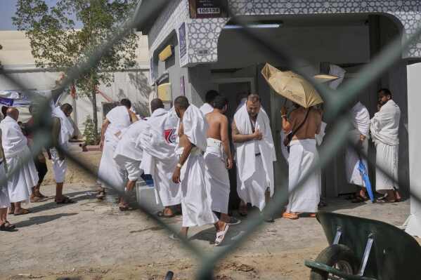Pilgrims wash for prayers near the rocky hill known as the Mountain of Mercy, on the Plain of Arafat, during the annual Hajj pilgrimage near the holy city of Mecca, Saudi Arabia, Thursday, June 5, 2025. (AP Photo/Amr Nabil)
