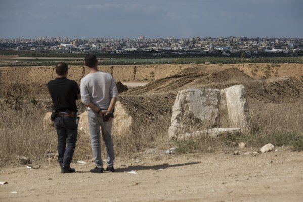
              Israelis look at the Gaza Strip border, Saturday, Oct. 27, 2018. The Israeli military has struck dozens of targets across the Gaza Strip in response to heavy rocket fire and threatened to expand its air campaign to Syria after accusing Iranian forces in Damascus of orchestrating the rocket attacks. (AP Photo/Tsafrir Abayov)
            