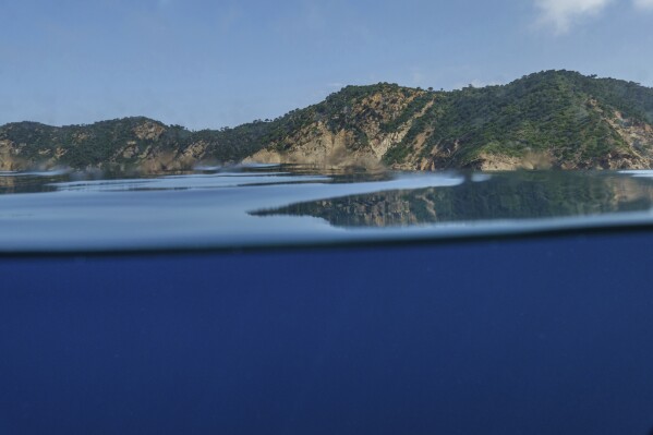Mountains are reflected in the waters of France's Port-Cros National Park ahead of the U.N. Ocean Conference, Saturday, June 7, 2025, (AP Photo/Annika Hammerschlag)