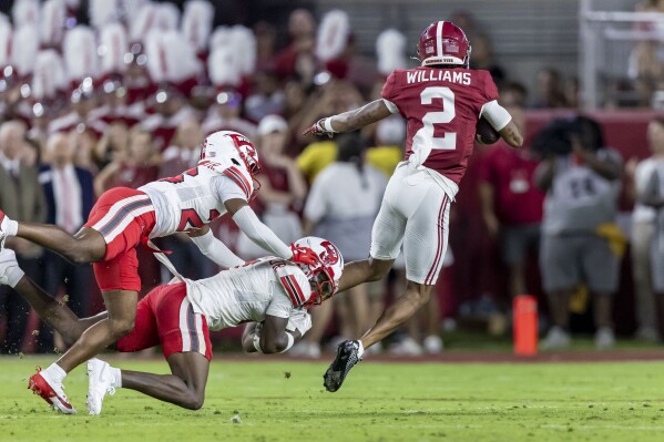 Alabama wide receiver Ryan Williams (2) grabs a pass and eludes Western Kentucky defensive backs Jai Eugene Jr., left, and Demarko Williams, for a 55-yard touchdown during the first half of an NCAA college football game, Saturday, Aug. 31, 2024, in Tuscaloosa, Ala. (AP Photo/Vasha Hunt)