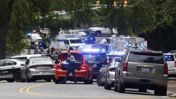 Law enforcement and first responders gather on South Street near the Bell Tower on the University of North Carolina at Chapel Hill campus in Chapel Hill, N.C., Monday, Aug. 28, 2023, after a report of an "armed and dangerous person" on campus. (Kaitlin McKeown/The News & Observer via AP)