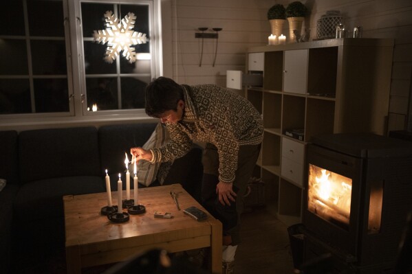 The Rev. Siv Limstrand lights candles at the church's cabin in Bolterdalen, Norway, Monday, Jan. 9, 2023. The cabin is used for retreats and church groups. (AP Photo/Daniel Cole)