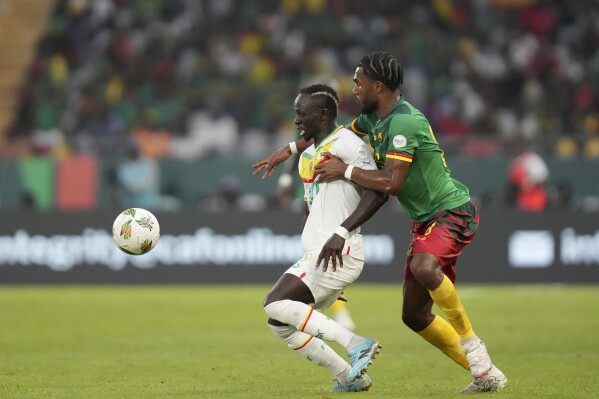 Senegal's Sadio Mane, left, is challenged by Cameroon's Enzo Tchato during the African Cup of Nations Group C soccer match between Senegal and Cameroon, at the Charles Konan Banny stadium in Yamoussoukro, Ivory Coast, Friday, Jan. 19, 2024. (AP Photo/Sunday Alamba)