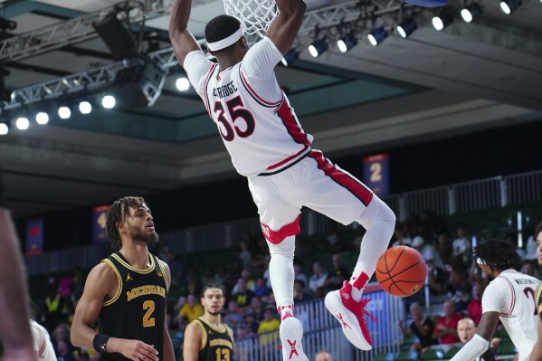 In a photo provided by Bahamas Visual Services, Texas Tech's Devan Cambridge (35) dunks during an NCAA college basketball game against Michigan in the Battle 4 Atlantis at Paradise Island, Bahamas, Friday, Nov. 24, 2023. (Ronnie Archer/Bahamas Visual Services via AP)