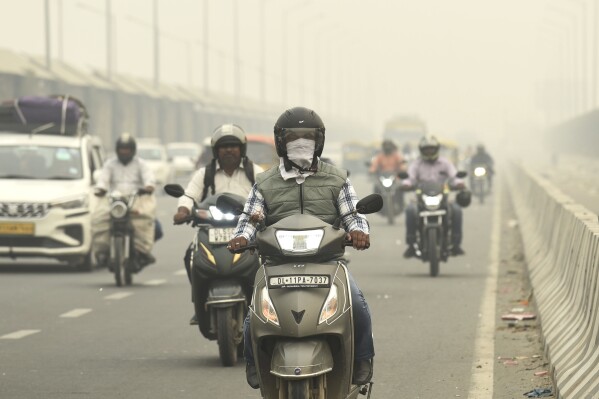 Traffic moves on a road enveloped by fog and smog in New Delhi, India, Friday, Nov. 3, 2023. Authorities on Friday shut primary schools and banned polluting vehicles and construction activity to control the worst haze and smog this season, causing respiratory infections among people and enveloping monuments and high-rise buildings in and around New Delhi. (AP Photo)