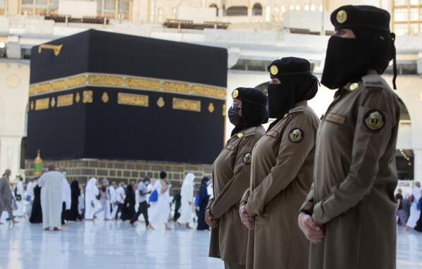 In this July 20, 2021 photo, Saudi police women, who were recently deployed to the service, from right to left, Samar, Alaa, and Bashair, stand alert in front of the Kaaba, the cubic building at the Grand Mosque, during the annual hajj pilgrimage in the Saudi Arabia's holy city of Mecca. The cloud of social restrictions that loomed over generations of Saudis is quickly dissipating and the country is undergoing visible change. Still, for countless numbers of people in the United States and beyond, Saudi Arabia will forever be associated with 9/11.  (AP Photo/Amr Nabil)
