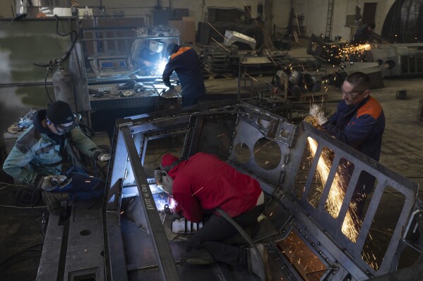 Workers weld reinforced steel for artillery vehicles at a factory in Ukraine, on Wednesday, January 31, 2024. (AP Photo/Evgeniy Maloletka)