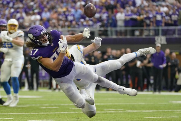 Minnesota Vikings tight end T.J. Hockenson, front, makes an attempt to catch a pass in the end zone as Los Angeles Chargers linebacker Nick Niemann defends during the second half of an NFL football game, Sunday, Sept. 24, 2023, in Minneapolis. The pass was intercepted in the end zone by Los Angeles Chargers linebacker Kenneth Murray Jr. The Chargers won 28-24. (AP Photo/Abbie Parr)