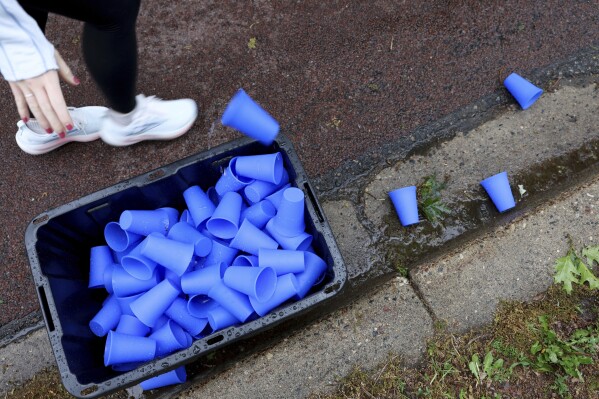 A runner discards a reusable silicone cup by Hiccup during the PNC Women Run the Cities race on Saturday, May 17, 2025, in Minneapolis. (AP Photo/Ellen Schmidt)