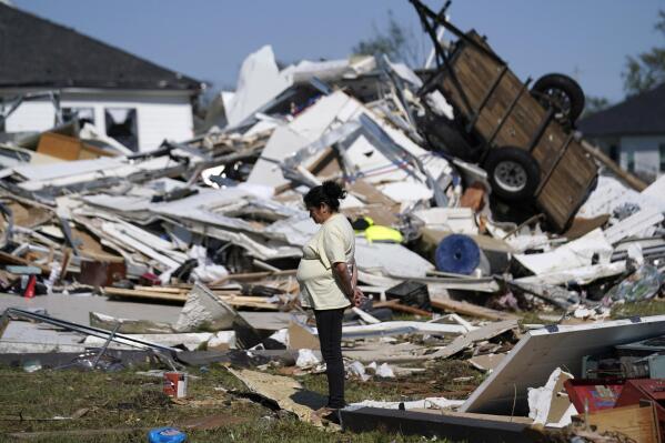 Bertelina Martinez, who lives nearby and her son lives across the street, looks over destruction after a tornado struck the area in Arabi, La., Wednesday, March 23, 2022. (AP Photo/Gerald Herbert)