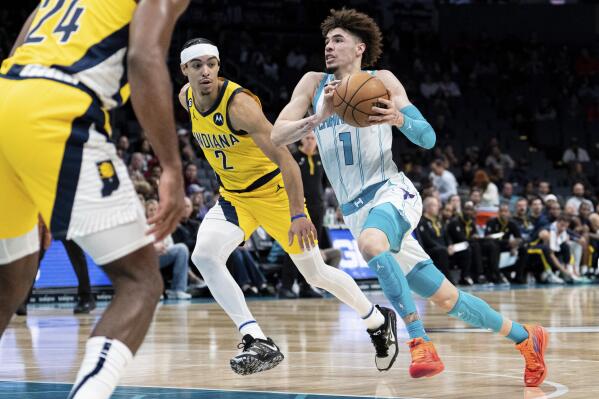 Charlotte Hornets guard LaMelo Ball (1) drives to the basket while guarded by Indiana Pacers guard Andrew Nembhard (2) during the first half of an NBA basketball game in Charlotte, N.C., Wednesday, Nov. 16, 2022. (AP Photo/Jacob Kupferman)