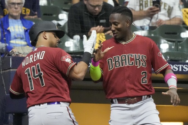 Arizona Diamondbacks' Gabriel Moreno celebrates with Geraldo Perdomo (2) after hitting a home run during the fourth inning of a Game 1 of their National League wildcard baseball game against the Milwaukee Brewers Tuesday, Oct. 3, 2023, in Milwaukee. (AP Photo/Morry Gash)