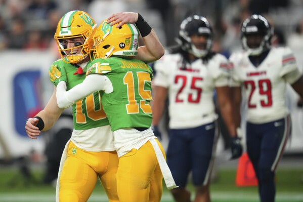 Oregon wide receiver Tez Johnson (15) celebrates his touchdown with quarterback Bo Nix (10) during the second half on the NCAA Fiesta Bowl college football game against Liberty, Monday, Jan. 1, 2024, in Glendale, Ariz. Oregon defeated Liberty 45-6. (AP Photo/Ross D. Franklin)