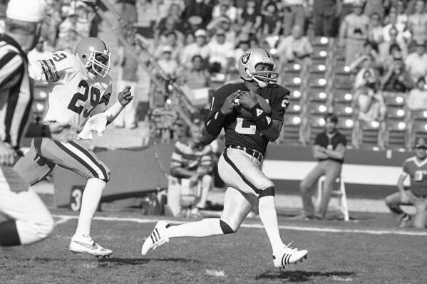 FILE - In this Saturday, Jan. 8, 1983 file photo, Los Angeles Raiders wide receiver Cliff Branch, right, catches a pass from quarterback Jim Plunkett for a 64 yard gain during the first quarter of their playoff game with the Cleveland Browns in Los Angeles. Three-time All-Pro receiver Cliff Branch and Super Bowl-winning coach Dick Vermeil are finalists for the Pro Football Hall of Fame’s class of 2022. (AP Photo/File)