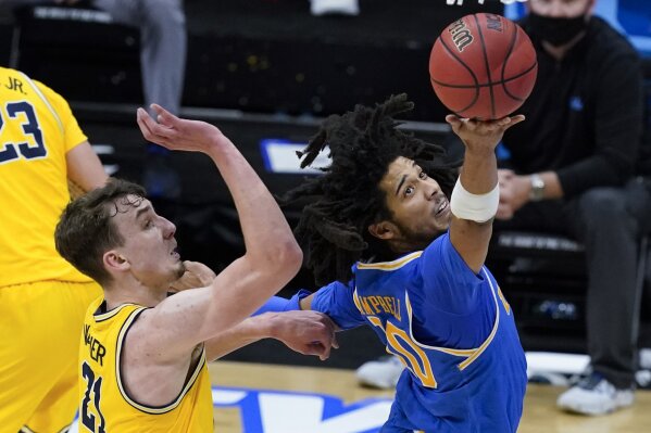 UCLA guard Tyger Campbell drives to the basket in front of Michigan guard Franz Wagner, left, during the second half of an Elite 8 game in the NCAA men's college basketball tournament at Lucas Oil Stadium, Tuesday, March 30, 2021, in Indianapolis. (AP Photo/Darron Cummings)