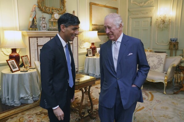 FILE - King Charles III, right, and Britain's Prime Minister Rishi Sunak smile during their meeting in Buckingham Palace, London, Feb. 21, 2024. Buckingham Palace says King Charles III will resume his public duties next week following treatment for cancer. The announcement on Friday April 26, 2024, comes almost three months after Charles took a break from public appearances to focus on his treatment for an undisclosed type of cancer. (Jonathan Brady/Pool Photo via AP, File)