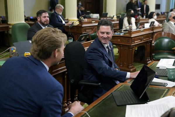 Assemblyman Jordon Cunningham, R-San Luis Obispo, right, smiles after his bill to hold social media companies responsible for harming children who have become addicted to their products was approved by the Assembly at the Capitol in Sacramento, Calif., on Monday, May 23, 2022. If approved by the Senate and signed by the governor, the bill would let parents sue platforms like Instagram and TikTok for up to $25,000 per violation. At left is Assemblyman Chad Mayes, I-Yucca Valley.  (AP Photo/Rich Pedroncelli)