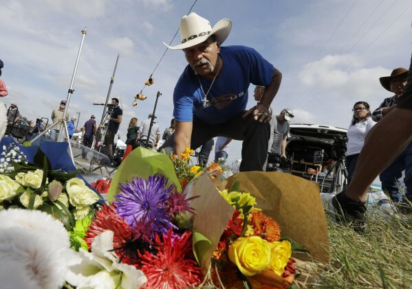 
              Rene Moreno drops off flowers at a makeshift memorial at the scene of a shooting at the First Baptist Church of Sutherland Springs, Tuesday, Nov. 7, 2017, in Sutherland Springs, Texas. A man opened fire inside the church in the small South Texas community on Sunday, killing more than two dozen and injuring others. (AP Photo/Eric Gay)
            