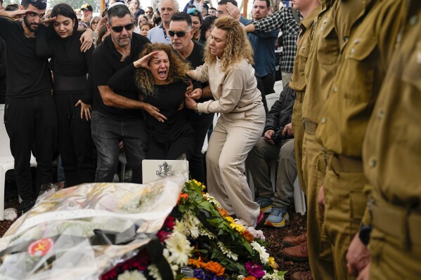 Sivan, mother of Israeli soldier, Sergeant Dolev Malca, screams as she salutes her son during his funeral in Shlomi, northern Israel, on the border with Lebanon, Sunday, March 3, 2024. Malca ,19, was killed during Israel's ground operation in the Gaza Strip, where the Israeli army has been battling Palestinian militants in the war ignited by Hamas' Oct. 7 attack into Israel. (AP Photo/Ariel Schalit)
