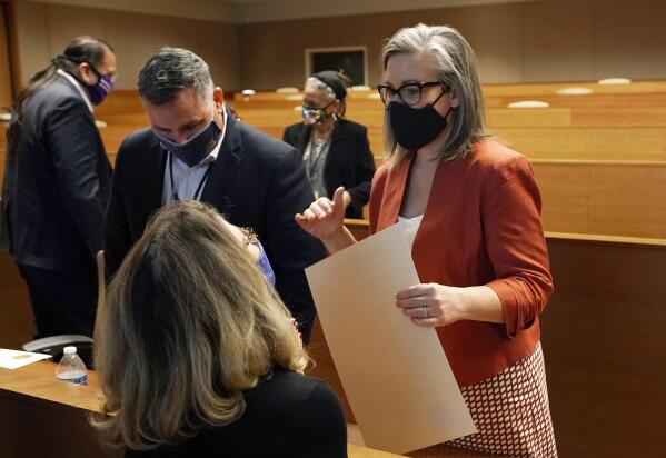 FILE - Arizona Secretary of State Katie Hobbs, right, talks with members of the Electoral College, including Felecia Rotellini, bottom left, and James McLaughlin, second from left, after the certification of the Arizona Presidential Electoral Ballot Monday, Dec. 14, 2020, in Phoenix. During the tumultuous period immediately following the November 2020 presidential election, election workers across the country faced harassment and threats. Since then, legislators in a small but growing number of states have proposed measures to help protect those workers by creating or boosting penalties for such threats or assaults. (AP Photo/Ross D. Franklin, File)