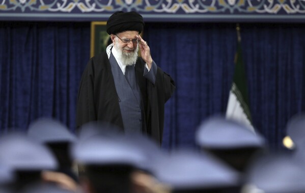 In this photo released by the office of the Iranian supreme leader, Supreme Leader Ayatollah Ali Khamenei salutes during a meeting with army's air force and air defense staff, in Tehran, Iran, Monday, Feb. 5, 2024. (Office of the Iranian Supreme Leader via AP)