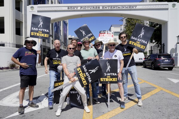 Cast and writers from "Breaking Bad" and "Better Call Saul" Juan Carlos Cantu, from left, Javier Grajeda, Aaron Paul, Charles Baker, Norma Maldonad, Jesse Plemons, Peter Gould, Bryan Cranston and Matt Jones, pose on a picket line outside Sony Pictures studios on Tuesday, Aug. 29, 2023, in Culver City, Calif. The film and television industries remain paralyzed by Hollywood's dual actors and screenwriters strikes. (AP Photo/Chris Pizzello)