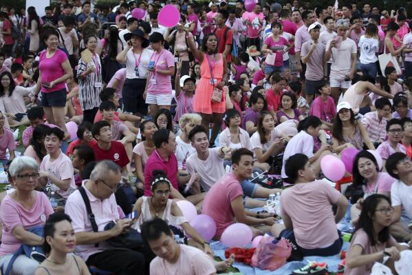FILE - Thousands of people gathered at a park for the annual Pink Dot gay pride event on Saturday, July 1, 2017, in Singapore. Singapore announced Sunday, Aug. 21, 2022, it will decriminalize sex between men by repealing a colonial-era law while protecting the city-state's traditional norms and its definition of marriage. (AP Photo/Wong Maye-E, File)