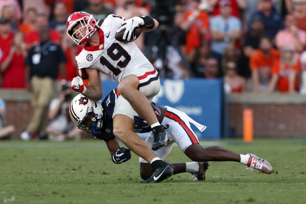 Georgia tight end Brock Bowers (19) is tackled by Auburn safety Caleb Wooden after a reception during the second half of an NCAA football game, Saturday, Sept. 30, 2023, in Auburn, Ala. (AP Photo/ Butch Dill )