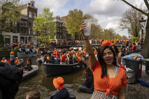 Varias personas celebran el Día del Rey en los canales de Ámsterdam, Holanda, el sábado 27 de abril de 2024. (AP Foto/Peter Dejong)