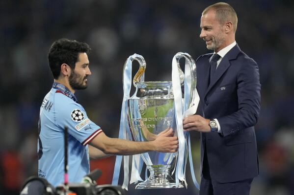 UEFA president Aleksander Ceferin hands the trophy to Manchester City's team captain Ilkay Gundogan after they won the Champions League final soccer match between Manchester City and Inter Milan at the Ataturk Olympic Stadium in Istanbul, Turkey, Sunday, June 11, 2023. Manchester City won 1-0. (AP Photo/Francisco Seco)