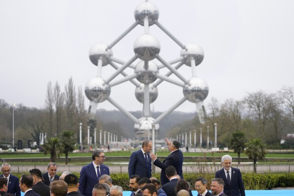 Hungary's Prime Minister Viktor Orban, center right, speaks with Poland's Prime Minister Donald Tusk, center left, after posing for a group photo in front of the Atomium during an Nuclear Energy Summit at the Expo in Brussels, Thursday, March 21, 2024. Leaders of European Union countries and other organizations meet for a one day summit on Thursday with the aim of highlighting the role of nuclear energy, reducing the use of fossil fuels, enhancing energy security and boosting economic development. (AP Photo/Virginia Mayo)