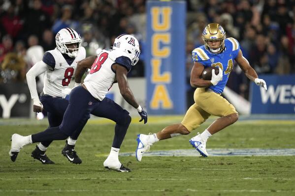 UCLA running back Zach Charbonnet, right, avoids Arizona linebacker Sterling Lane II, left, and linebacker Jerry Roberts during the first half of an NCAA college football game Saturday, Nov. 12, 2022, in Pasadena, Calif. (AP Photo/Mark J. Terrill)