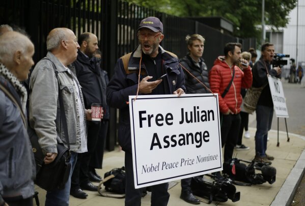 
              Protesters stand with media journalists outside court as Julian Assange is to appear at court to be sentenced on charges of jumping British bail seven years ago, in London, Wednesday May 1, 2019. Founder of WikiLeaks Assange was arrested at the Ecuadorian embassy April 11, after his political asylum was withdrawn. (AP Photo/Matt Dunham)
            