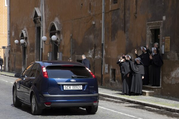 Nuns wave to Pope Francis as he leaves the Santo Spirito in Sassia Church where he celebrated a Mass, in Rome Sunday, April 19, 2020. (AP Photo/Alessandra Tarantino)