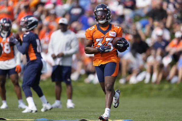 FILE -Denver Broncos running back Javonte Williams takes part in drills during the NFL football team's training camp Friday, July 29, 2022, in Centennial, Colo. Broncos running back Javonte Williams is using his downtime as he recovers from an injured right knee to feed his other passion: helping foster kids.(AP Photo/David Zalubowski, File)