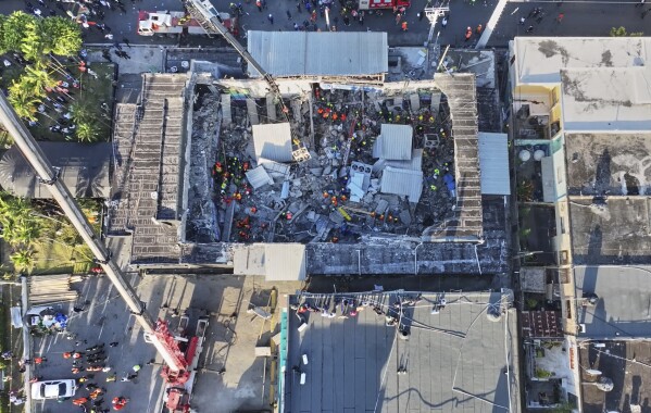 Rescue workers search for survivors at the Jet Set nightclub after its roof collapsed during a merengue concert in Santo Domingo, Dominican Republic, Tuesday, April 8, 2025.(Noticias SIN via AP)