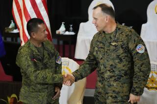 US Marine Corp MGEN Eric Austin, U.S. Exercise Director Representative, right, and Philippine Army MGEN Marvin Licudin, Philippine Exercise Director shake hands at the opening ceremonies of a joint military exercise flag called "Balikatan," a Tagalog word for "shoulder-to-shoulder," at Camp Aguinaldo military headquarters Tuesday, April 11, 2023, in Quezon City, Philippines. The United States and the Philippines on Tuesday launch their largest combat exercises in decades that will involve live-fire drills, including a boat-sinking rocket assault in waters across the South China Sea and the Taiwan Strait that will likely inflame China. (AP Photo/Aaron Favila)
