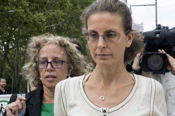 
              FILE- In This July 25, 2018 file photo, Clare Bronfman, right, leaves Federal court with her attorney Susan Necheles, in the Brooklyn borough of New York. Bronfman, an heir to the Seagram liquor fortune, once financed NXIVM, a group whose leader Keith Raniere faces charges in federal court of forming a secret society within his organization that forced women to have sex with him. (AP Photo/Mary Altaffer, File)
            