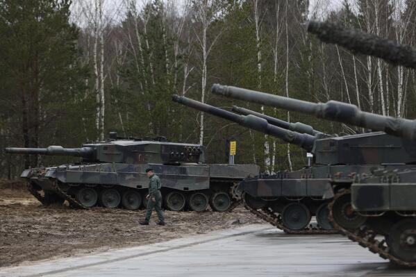 A Polish soldier walks next to the Leopard 2 tanks during a training at a military base and test range in Swietoszow, Poland, Monday, Feb. 13, 2023. The training is part of the European Union's military assistance to Ukraine. (AP Photo/Michal Dyjuk)