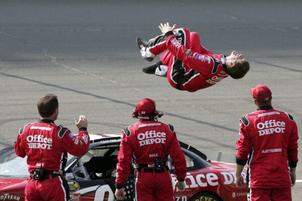 FILE - Carl Edwards does a backflip at the finish line after winning the NASCAR Cup Series auto race at Michigan International Speedway in Brooklyn, Mich., June 17, 2007. Edwards, one of NASCAR’s top 75 drivers, was elected to the NASCAR Hall of Fame last week based on his 28 career Cup victories. He said his election to the Hall was a surprise he didn’t see coming. (AP Photo/Bob Brodbeck, File)