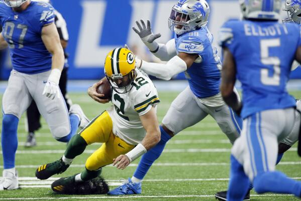 Green Bay Packers quarterback Aaron Rodgers (12) slides as Detroit Lions linebacker Julian Okwara chases during the second half of an NFL football game, Sunday, Nov. 6, 2022, in Detroit. (AP Photo/Duane Burleson)