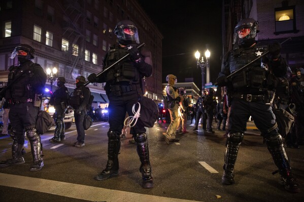FILE - In this Nov. 4, 2020, file photo, police form a perimeter during protests following the Nov. 3 presidential election in Portland, Ore. City leaders in Portland, on Wednesday, March 20, 2024, are reviving a protest response team though some residents are skeptical and say their confidence was eroded by the police response to 2020 racial justice protests in the city. (AP Photo/Paula Bronstein, File)