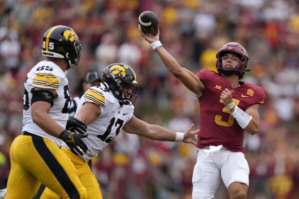 Iowa State quarterback Rocco Becht (3) passes over Iowa defensive end Joe Evans (13) and defensive lineman Logan Lee (85) during the first half of an NCAA college football game, Saturday, Sept. 9, 2023, in Ames, Iowa. (AP Photo/Charlie Neibergall)