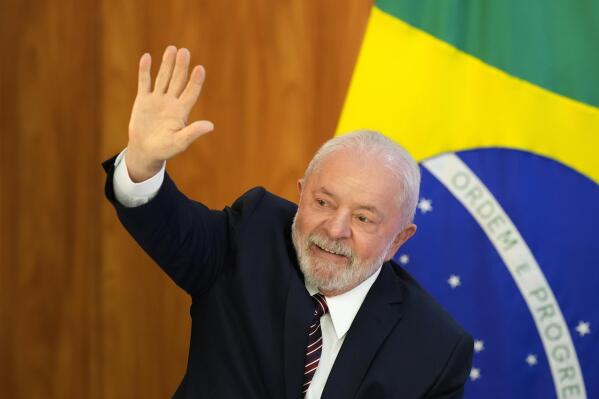 Brazilian President Luiz Inacio Lula da Silva waves as he arrives for a ministerial meeting to review the first 100 days of his government at Planalto Palace in Brasilia, Brazil, Monday, April 10, 2023. (AP Photo/Eraldo Peres)