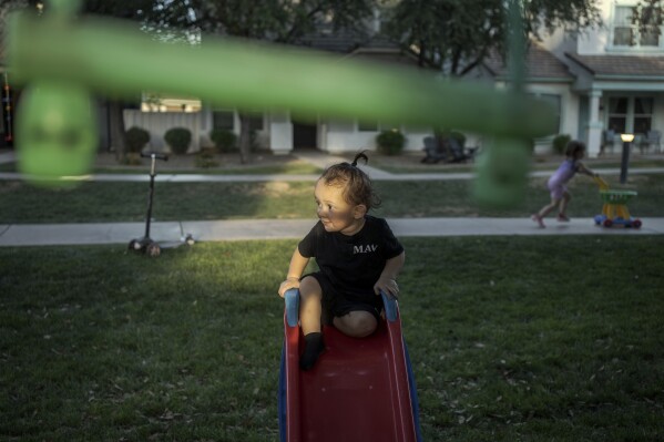 Liam Guerena plays in a "kid pod," a cluster of families with more than 20 kids between them, at Agritopia, a community nestled around a plot of agricultural land, April 21, 2025, in Gilbert, Ariz. (AP Photo/Annika Hammerschlag)